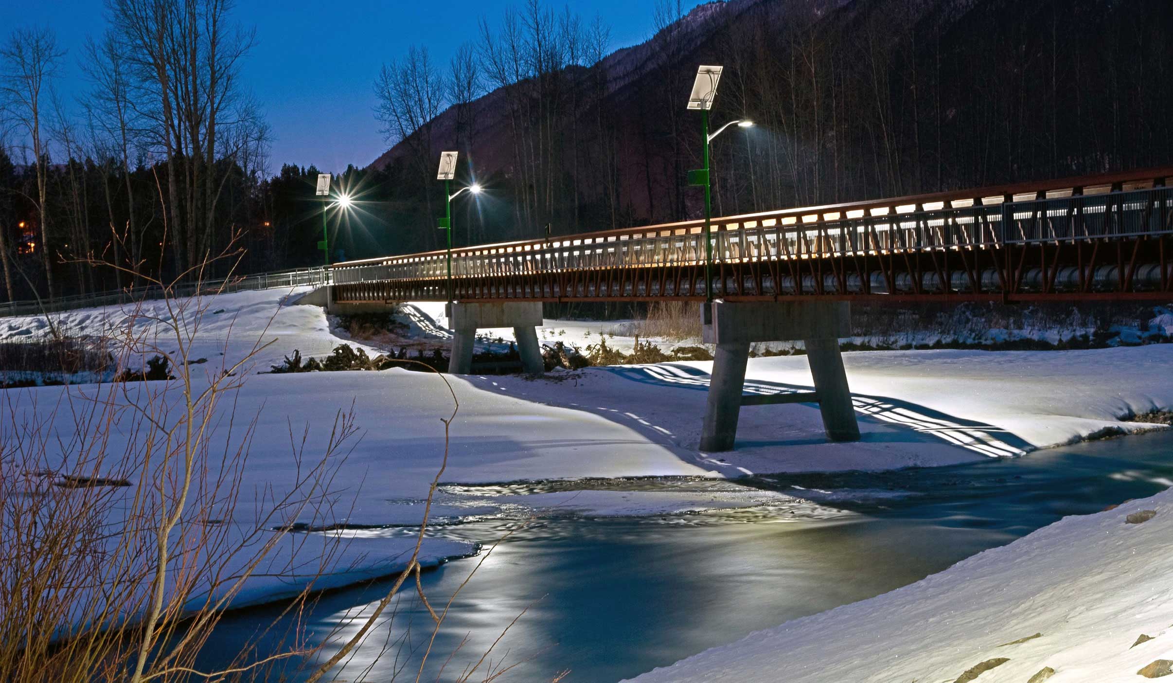 Solar PV street lightposts lighting up a bridge in winter with Blue Sky Energy controllers that can adapt to seasonal changes and harsh weather conditions